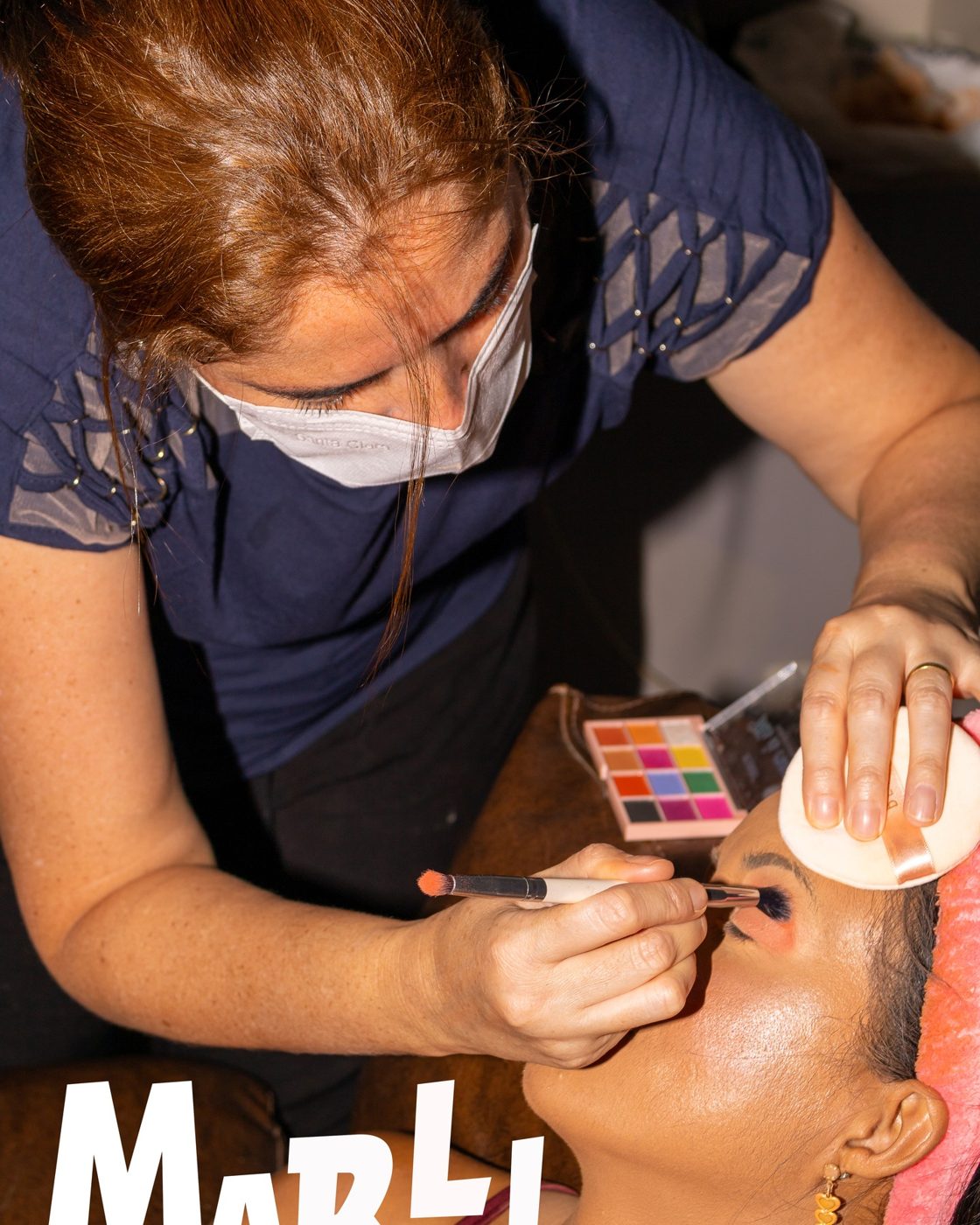 Maquiadora aplicando sombra colorida na modelo Marli