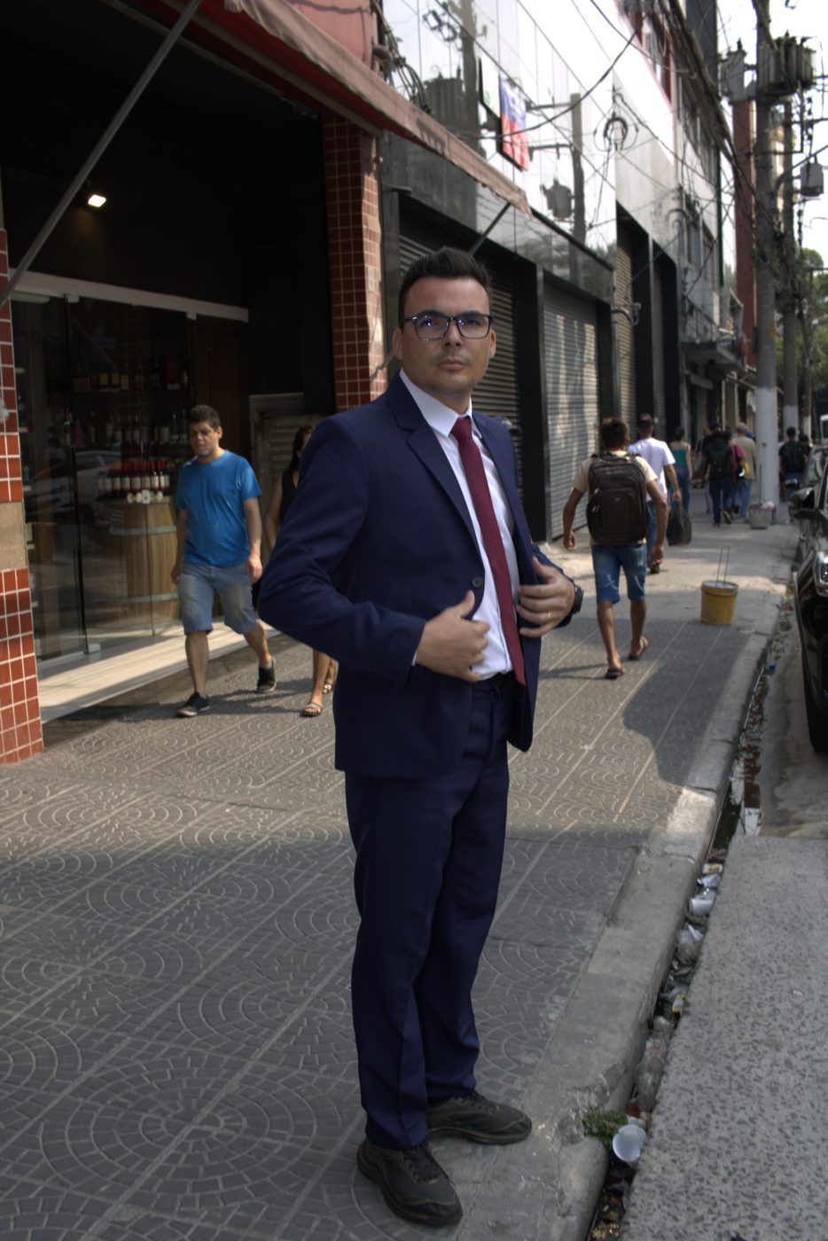 Modelo de terno ajustando o paletó na calçada